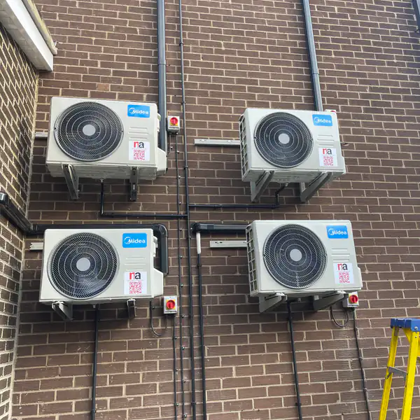 Four outdoor air conditioning condensers on a commercial building in Bristol